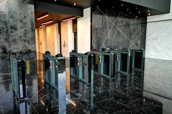 Optical turnstiles in a lobby with dark marble finishes Optical turnstiles in a lobby with dark marble finishes