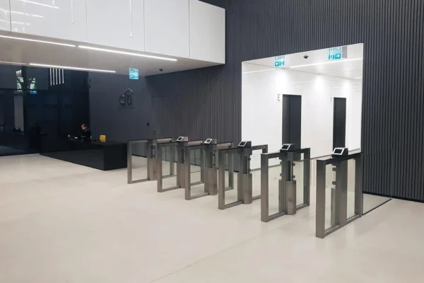 Optical turnstiles in a modern lobby with dark wall panels Optical turnstiles in a modern lobby with dark wall panels